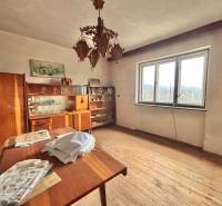 Szoba családi házban fa dekorációval, vintage bútorokkal, csillárral és nagy ablakkal.