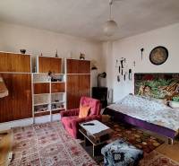 Nappali egy családi házban szőnyeggel, kanapéval és polcos tárolórendszerrel.