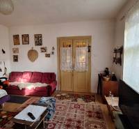 Nappali egy családi házban antik bútorokkal és dekorációkkal, fa mintázatú padlóval.