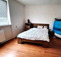 Hálószoba családi házban ággyal, komóddal és fa dekorációs padlóval.