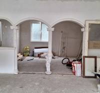 Családi ház belső tér boltívekkel és oszlopokkal, befejezetlen felújítás.