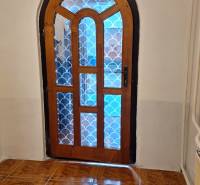 Boltíves faajtó mintás üveggel a családi házban, fa dekoros padló.