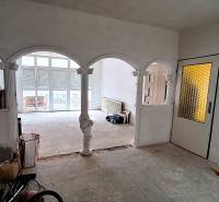 Családi ház belső tere boltívekkel és üvegezett ajtókkal. Javítások folynak.