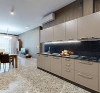 Konyha egy háromszobás lakásban márványpadlóval és világos bútorokkal.