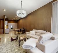 Nappali bézs kanapéval és nyitott konyhával egy háromszobás lakásban.