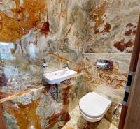 Fürdőszoba feltűnő kőburkolattal egy háromszobás lakásban.