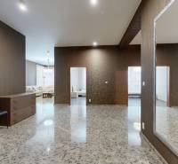 Tágas folyosó csempével, tükörrel, két székkel és kilátással a nappalira.