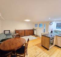 Nappali egy egyszobás lakásban, fa dekoros padlóval, kanapéval és étkezőasztallal.