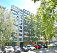 Egy lakóház az Antolska utcában, Pozsony-Petržalkán, zöldövezettel és parkoló autókkal körülvéve.