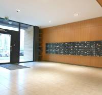 Bejárati előtér postaládákkal és üvegezett ajtókkal egy kétszobás lakás épületében.