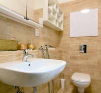 Fürdőszoba egy kétszobás lakásban mosdóval, WC-vel és bézs csempével.