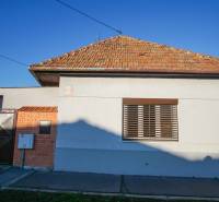 Családi ház Érsekújváron, a Pod kopcom utcában, téglatetővel és fémkapuval.