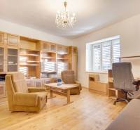 Családi ház belső tere bútorokkal, fa mintázatú padlóval és csillárral.