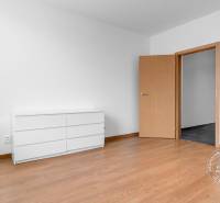 Szoba világos bútorokkal és fa dekorációjú padlóval egy háromszobás lakásban.