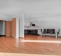 Nappali konyhával egy háromszobás lakásban, fa dekorációjú padlóval, étkező sarokkal.