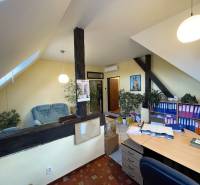 Iroda egy épületben, fa dekoros padlóval, irattartó polcokkal és ülősarokkal.