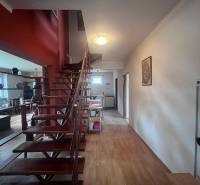 Családi ház belső tere fa lépcsőkkel és fa dekorációjú padlóval.