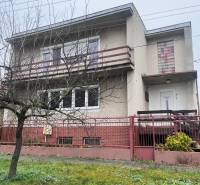 Családi ház Dlhá nad Váhom-ban beton homlokzattal, erkéllyel és előkerttel.