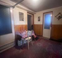 Családi ház belső tere fa burkolattal, asztallal és székkel.