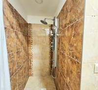 Kerámia burkolatú és zuhanyfüggönyös zuhanykabin a háromszobás lakásban.