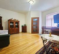 Nappali egy háromszobás lakásban, fa dekoros padlóval és sötét fa bútorokkal.