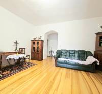 Nappali egy háromszobás lakásban, fa dekorációjú padlóval és fa bútorokkal.