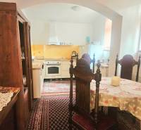 Konyha egy háromszobás lakásban fa bútorokkal és vintage szőnyeggel.