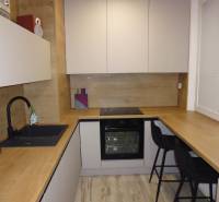 Konyha fa dekor padlóval egy kétszobás lakásban, kényelmes ülőhellyel felszerelve.