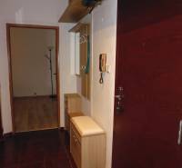 2 szobás lakás előszobája sötét padlóval és világos bútorokkal.