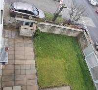 Kilátás egy családi ház kertjére és teraszára az utcai parkolással a Súľovská utcában.