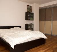 Hálószoba családi házban ággyal és szekrénnyel, fa dekoros padlóval.