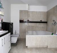 Fürdőszoba nagy káddal és világos csempékkel egy családi házban.