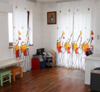 Gyerekszoba egy családi házban színes függönyökkel és fa dekorációjú padlóval.