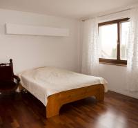 Hálószoba családi házban ággyal, székkel és fa dekorációjú padlóval.