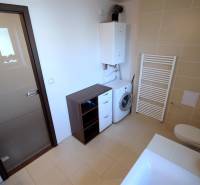 Fürdőszoba káddal, mosdóval, mosógéppel és szekrényekkel egy kétszobás lakásban.