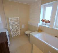 Fürdőszoba káddal, csempével és mosógéppel egy kétszobás lakásban.