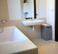 Fürdőszoba káddal, mosdóval és mosókosárral egy kétszobás lakásban.