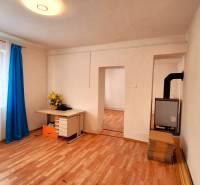 Családi ház fa mintázatú padlóval, függönyös ablak és íróasztal.