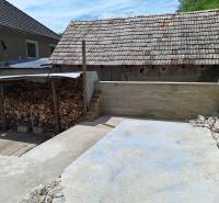 A Hajnáčkai családi ház udvara fatárolóval és betonterülettel.