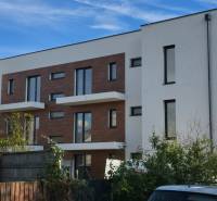 Fehér épület fa részletekkel a Banka utcában, Pöstyénben.