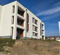 Új épületek a Banka utcában Pöstyénben fehér homlokzattal és fa dekorációval kombinálva.