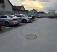 Parkoló a Banka utcában, Pöstyénben, autókkal és teherautóval naplementekor.