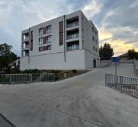 Lakóépület Pöstyénben, a Banka utcán, az út mellett járdával és korláttal.