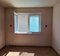 Szoba egy családi házban nyitott ablakkal és fa dekorációjú padlóval.