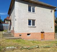 Családi ház Sídon meredek tetővel és gondozott kerttel, gyepesítve.