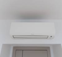 Légkondicionáló a háromszobás lakásban, fehér egység a fehér falon.