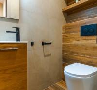 Fürdőszoba egy háromszobás lakásban, fa dekoros padlóval és csempével.