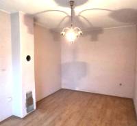 Szoba egy családi házban fa dekorációjú padlóval és függőlámpával.