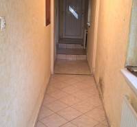 Keskeny beltéri folyosó csempével és fa mennyezettel egy családi házban.