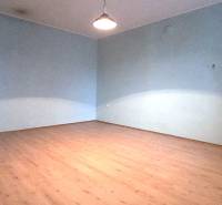 Egy családi ház szobája fa dekoros padlóval és kék falakkal.